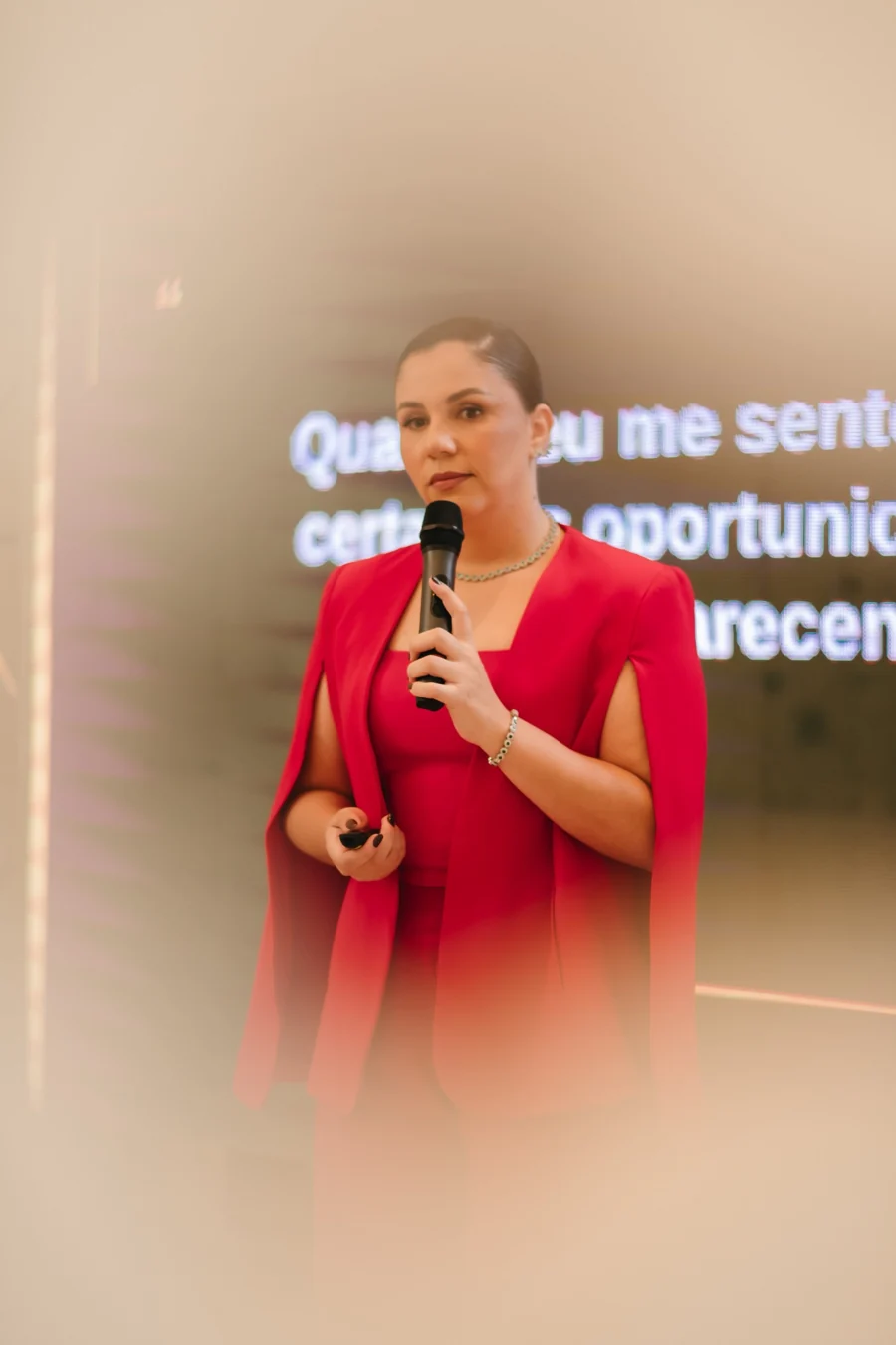 Lilian Arcanjo durante uma palestra, segurando o microfone